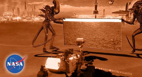 火星探査機に荒野の写真を見せるエイリアン二匹